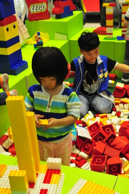 小朋友沉浸在樂高積木的世界里，專心致志地拼搭自己的作品。